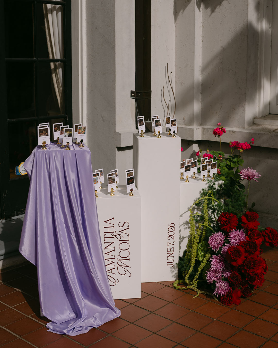 wedding seating chart on pillars with floral arrangement