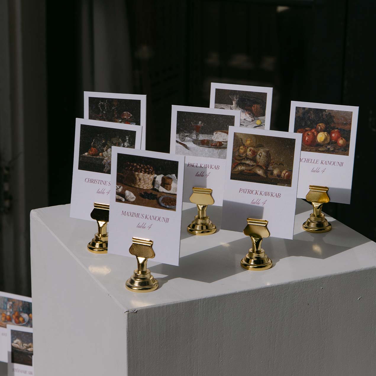 Wedding stationery escort cards on gold stands displayed on pillars